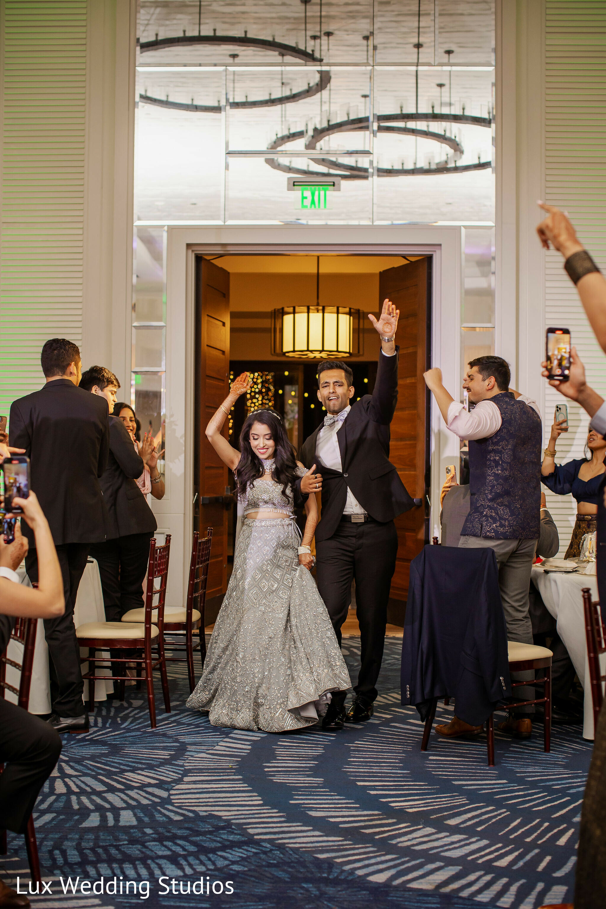 Joyful Indian bride and grooms entrance to wedding reception capture