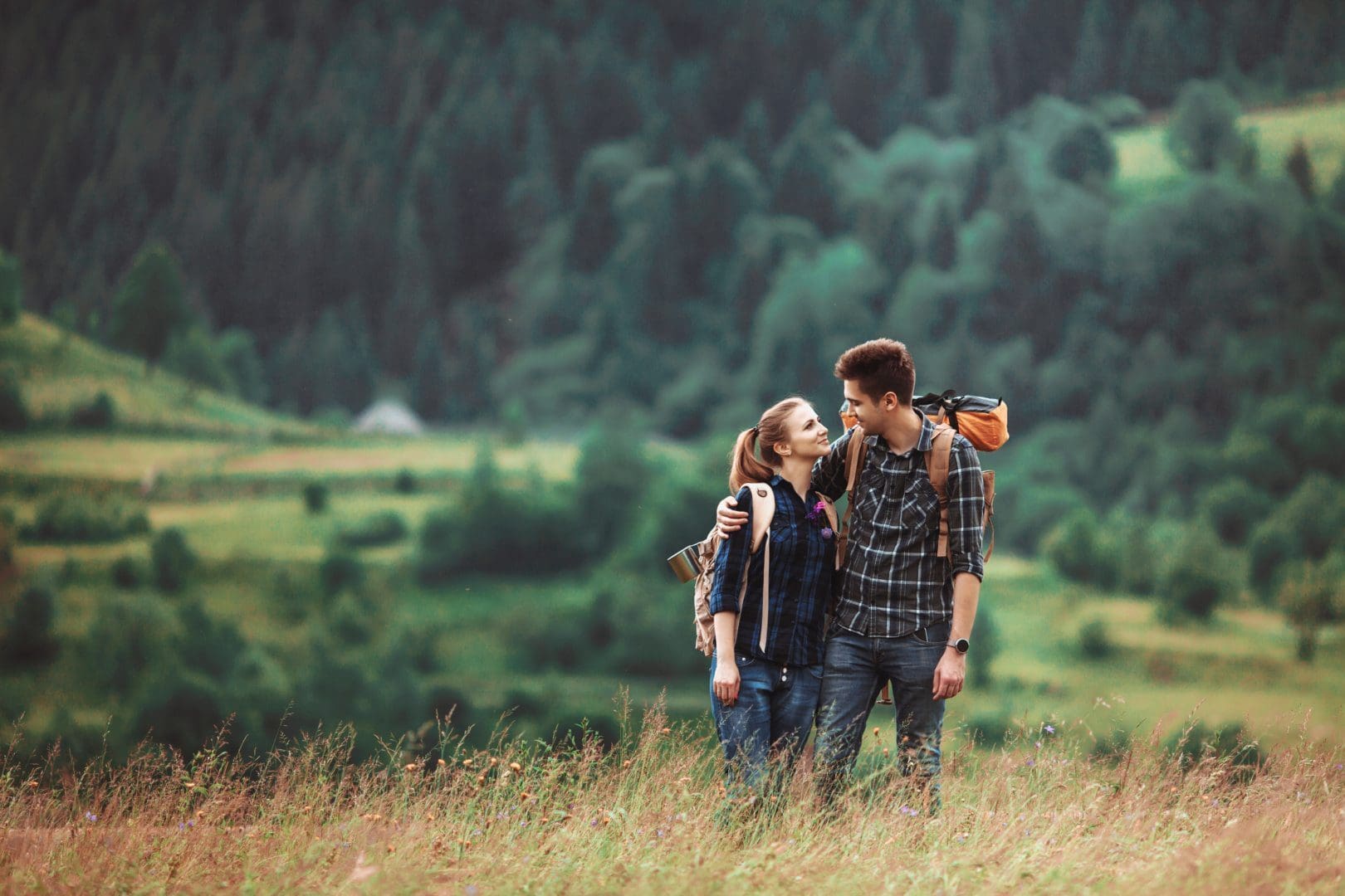 A couple hikers Hiking with backpacks walk along a beautiful mountain