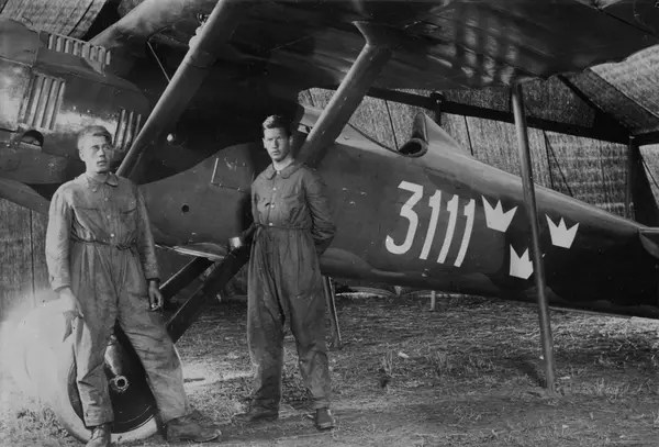 Porträtt. Två flygmekaniker står vid flygplan FVM J 23 märkt nummer