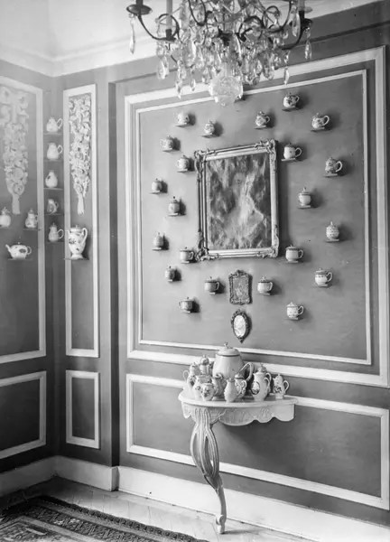 Rikt dekorerad vägg med flertalet porslinsföremål. I taket