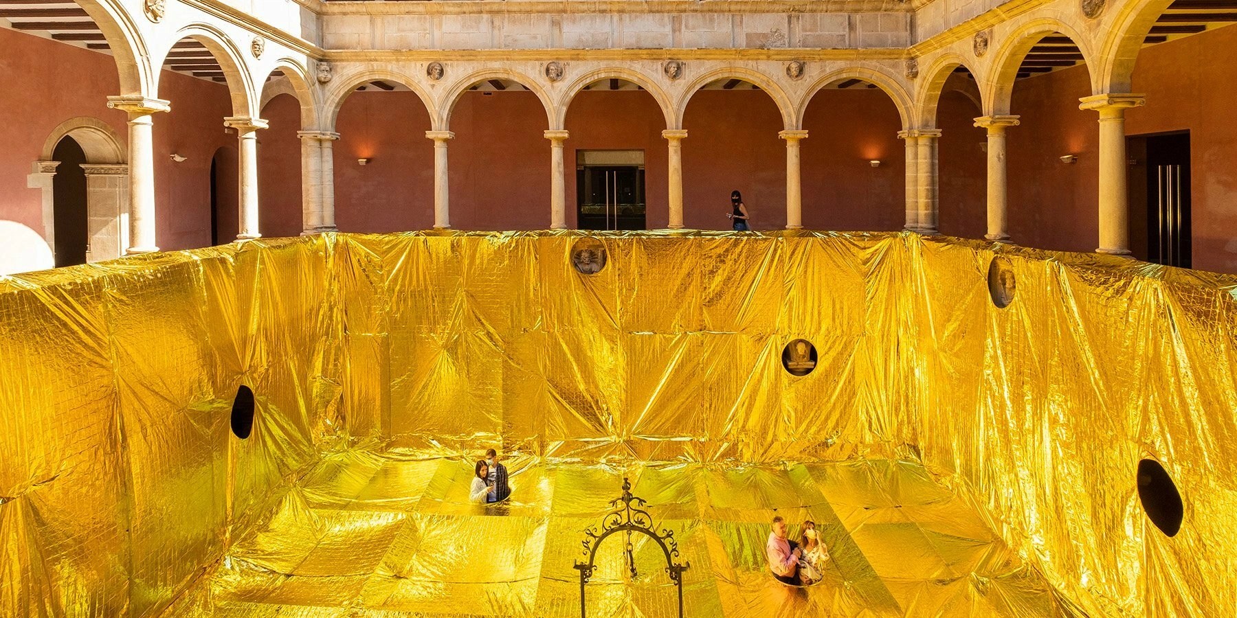 Adrian R. 16thcenturypatiocoveredwithgoldemergencyblanketsin