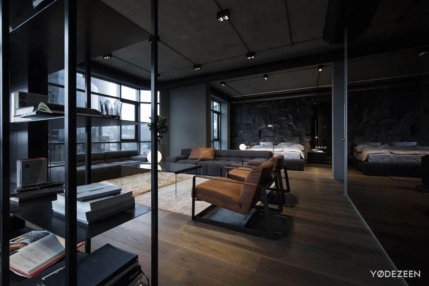 Apartment in concrete, dark surfaces and dramatic lighting