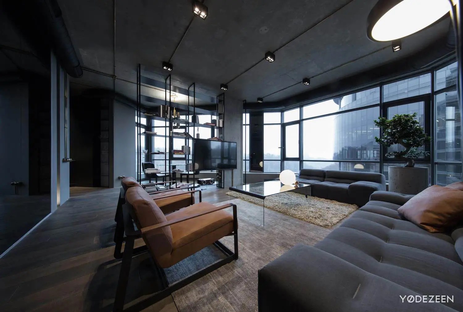 Apartment in concrete, dark surfaces and dramatic lighting