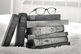 stack of old novel hardback books,eye glasses on top, on romantic love