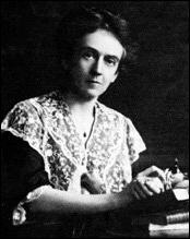 A portrait photograph of Edith Hamilton as she works on her writing, glancing at the photographer.