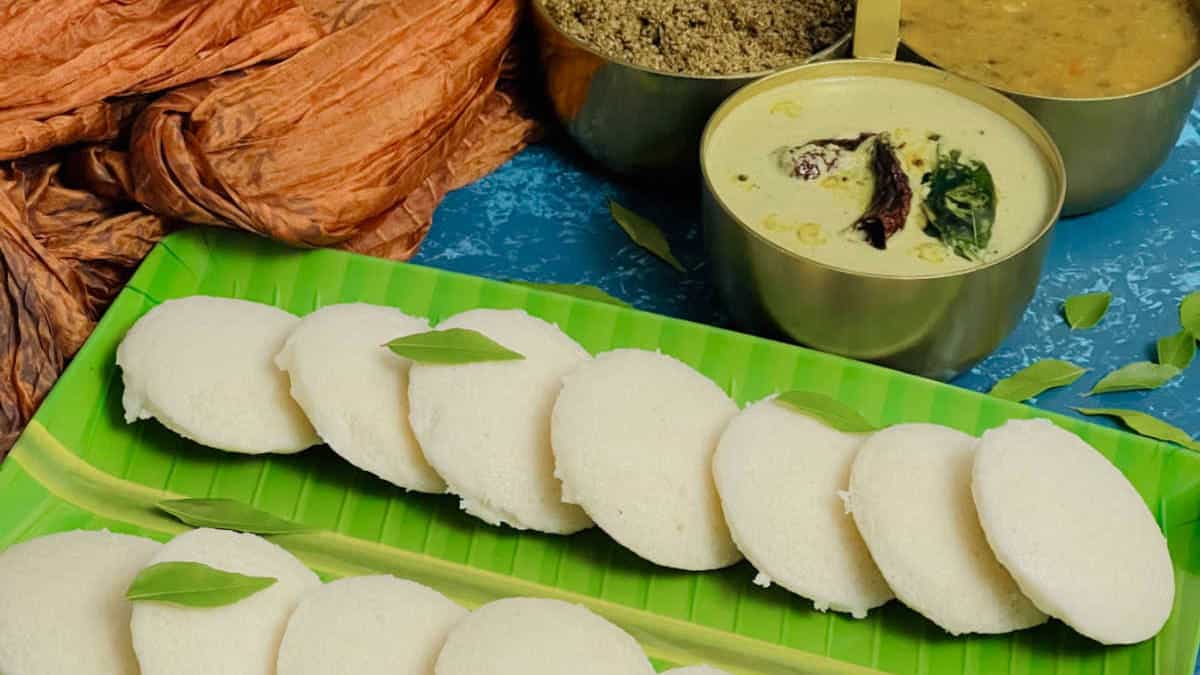 Idli served on a banana leaf plate.