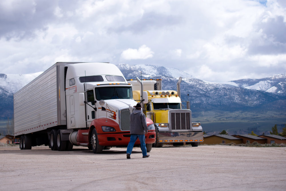 Truck driver going to his semi truck rig on parking lot