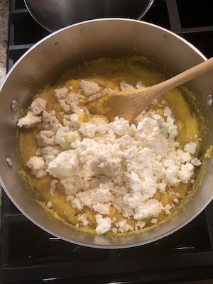Adding the feta cheese to mamaliga