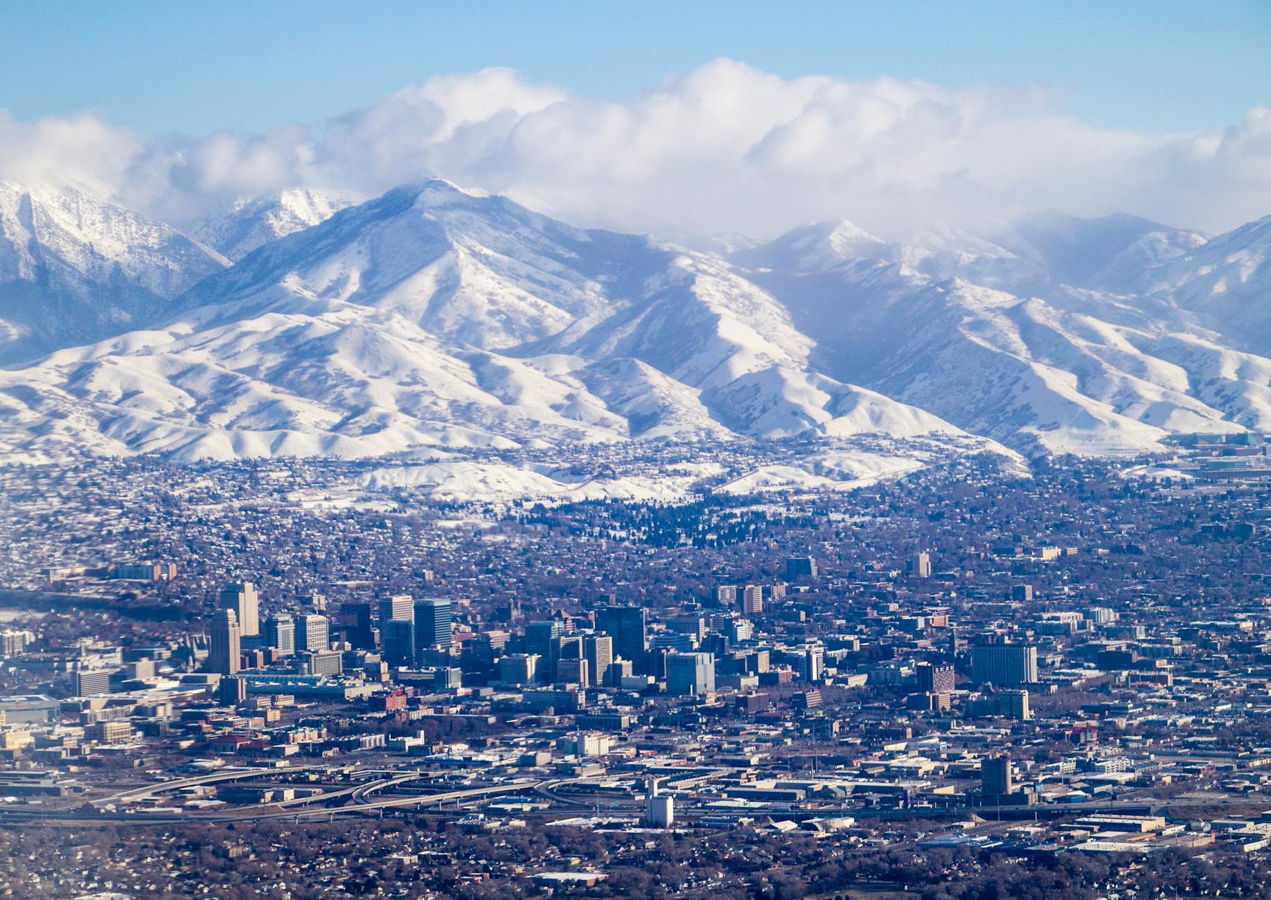 aerial view of a city by the snowy mountains