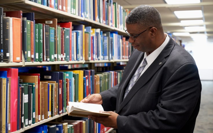 Man reads book at Family History Library