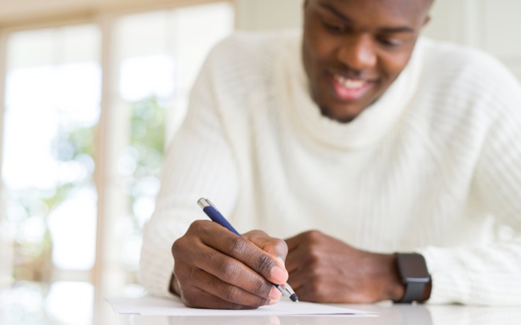 a black man celebrates black history month writes his personal history in a journal
