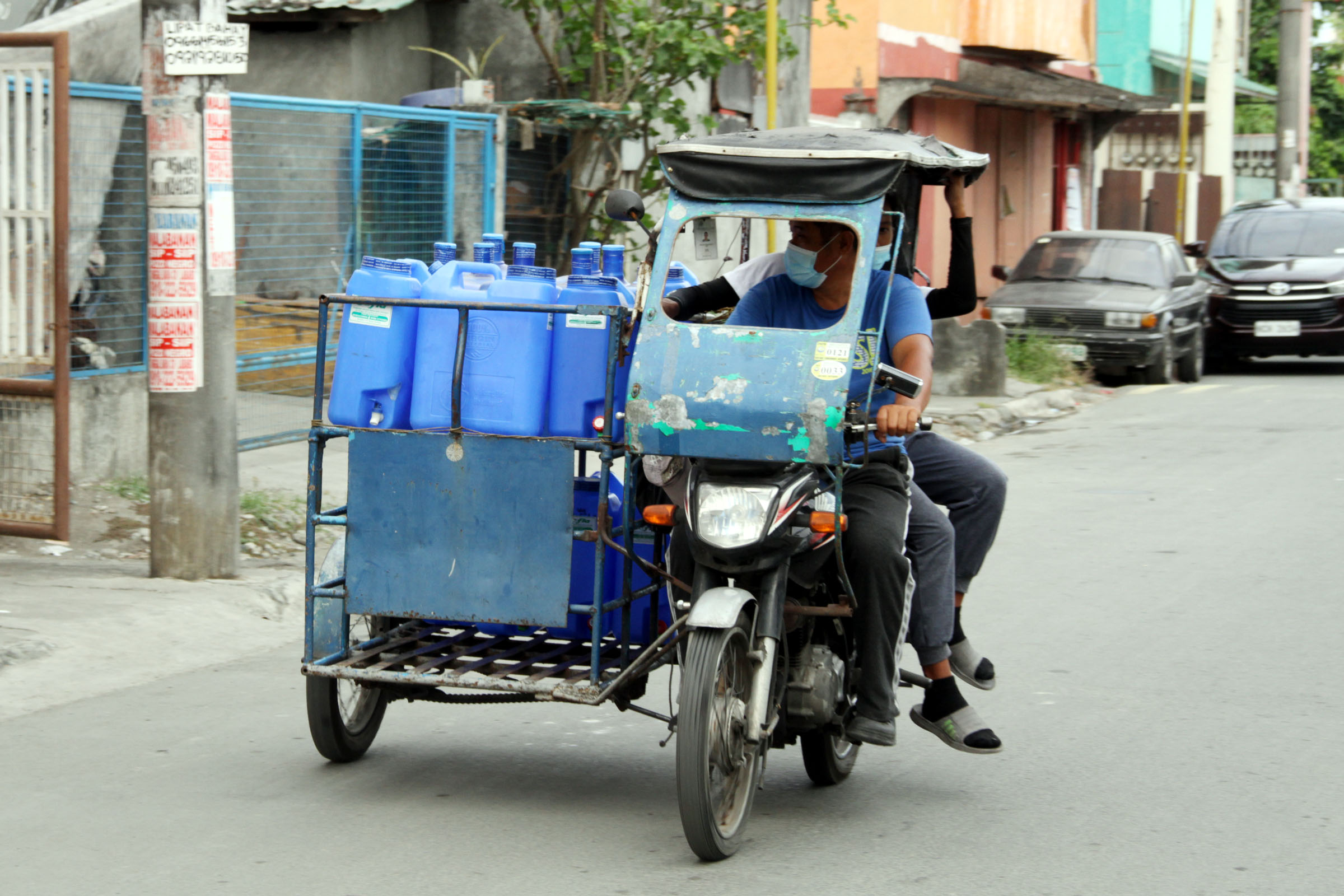 A tricycle driver pass speed delivery a mineral waters at Cavite