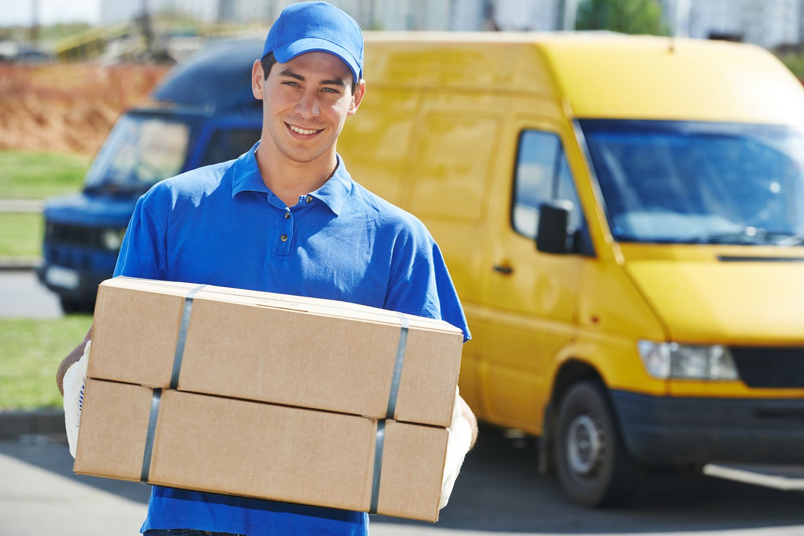 Smiling young male postal delivery courier man in front of cargo Flex