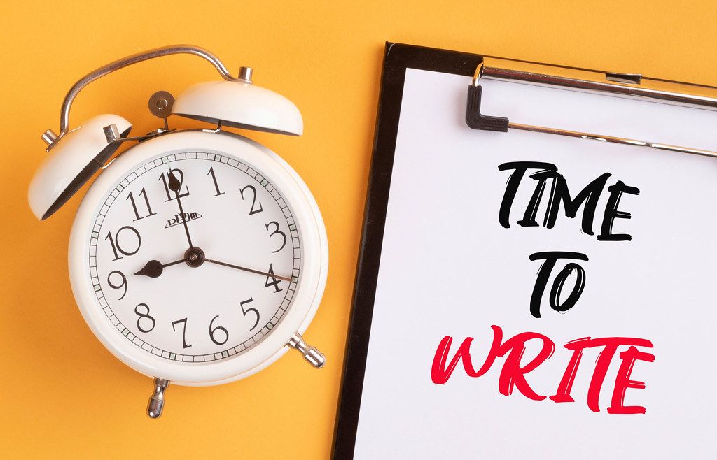 Alarm clock with handwritten text Time to Adapt on clipboard Creative