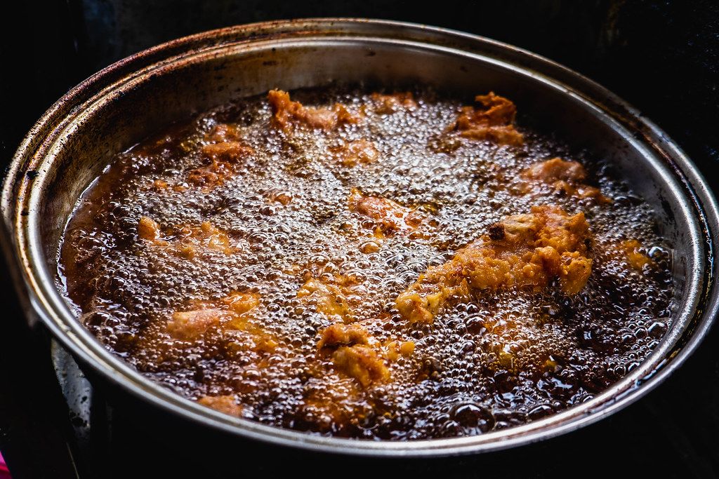 Chicken being cooked in a deep fry pot Creative Commons Bilder