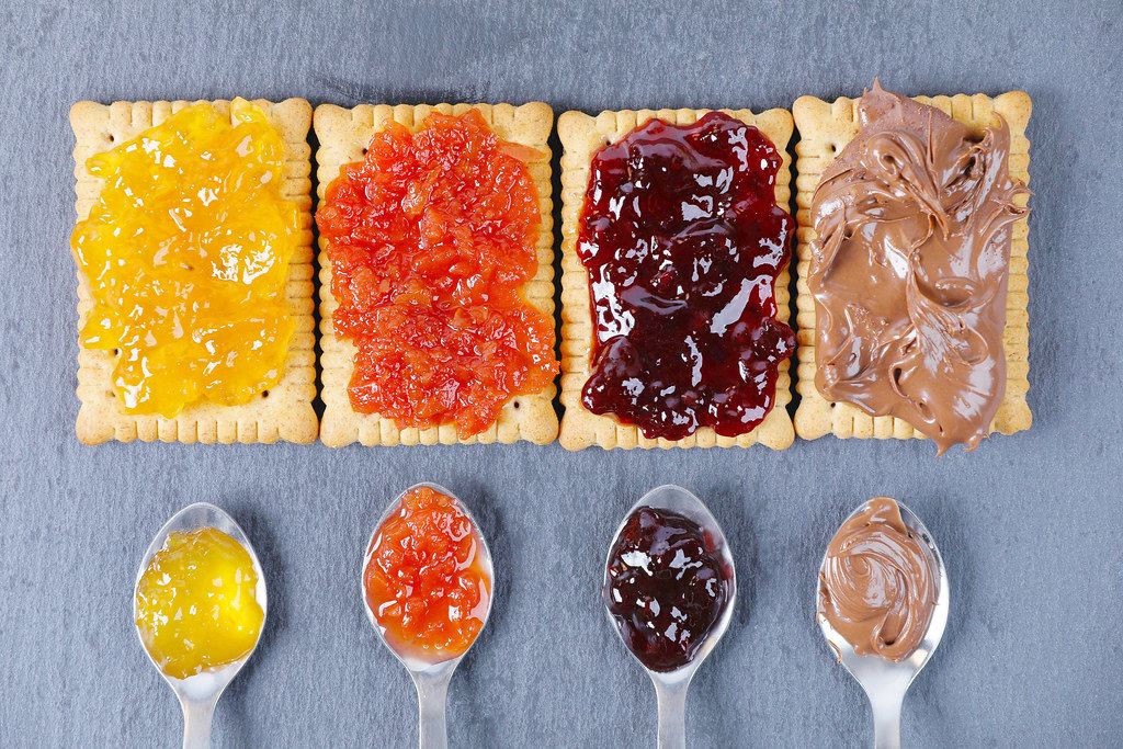 Chocolate cream and fruits jam on biscuit and on spoon. Sandwich