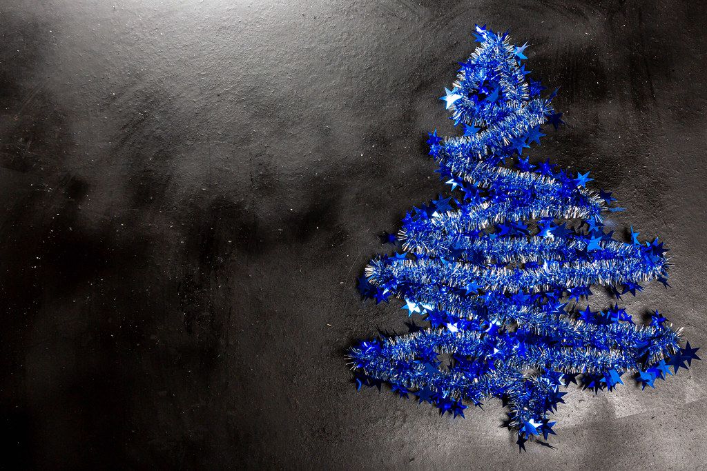 The girl puts a star on the top of the Christmas tree Creative