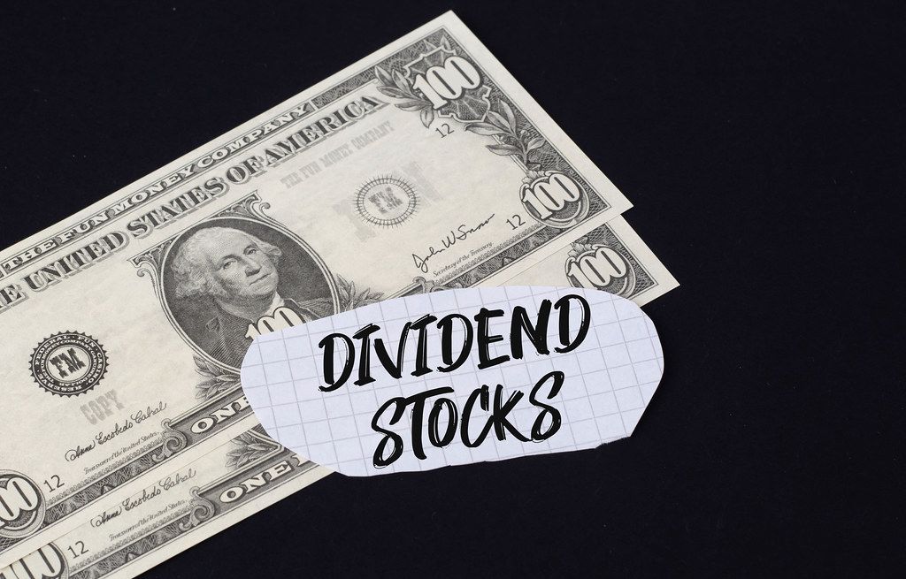 Dividend Stocks text and dollar banknotes Creative Commons Bilder
