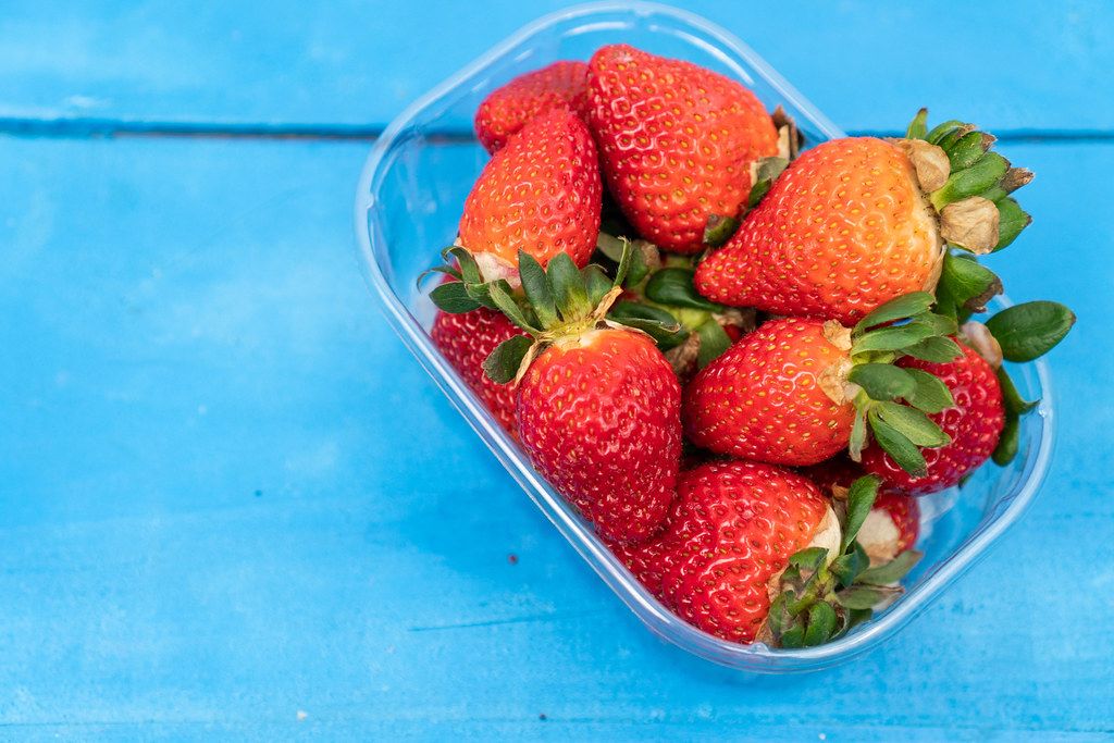 Fresh strawberries with blurred strawberries in the bowl Creative