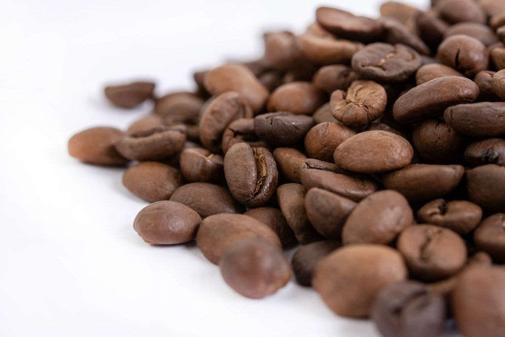 Instant coffee and whole coffee beans on a white background with an