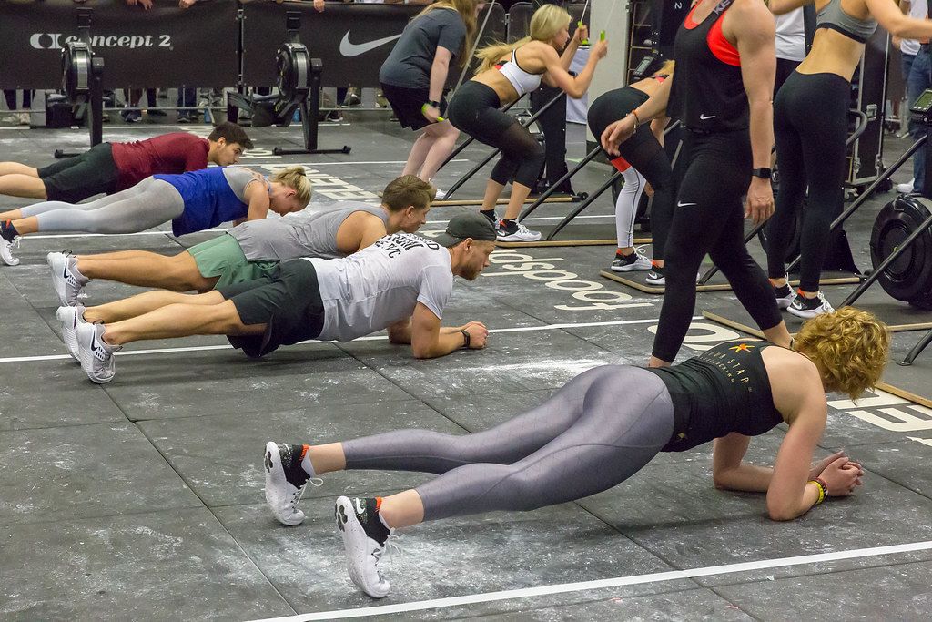 People doing a plank next to each other while others do People doing a plank next to each other while others do