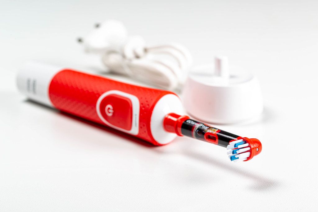 Red electric toothbrush with charger Creative Commons Bilder