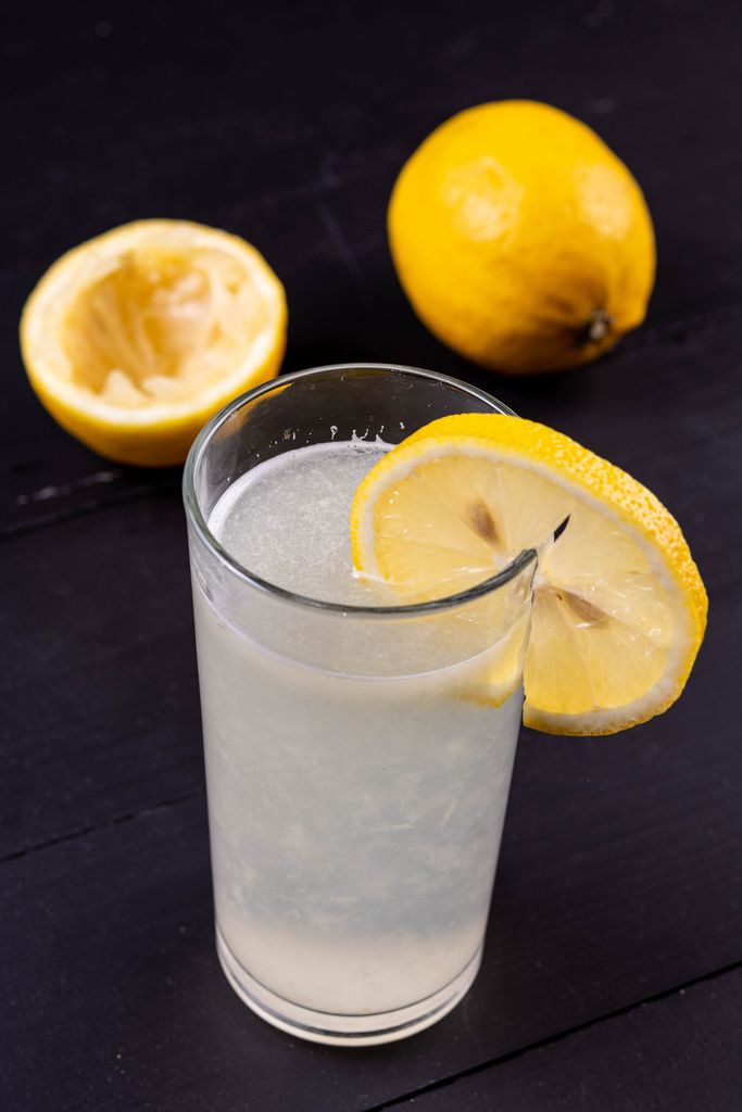 Glass jug of cold lemonade on a light background cafe. Pitcher lemon