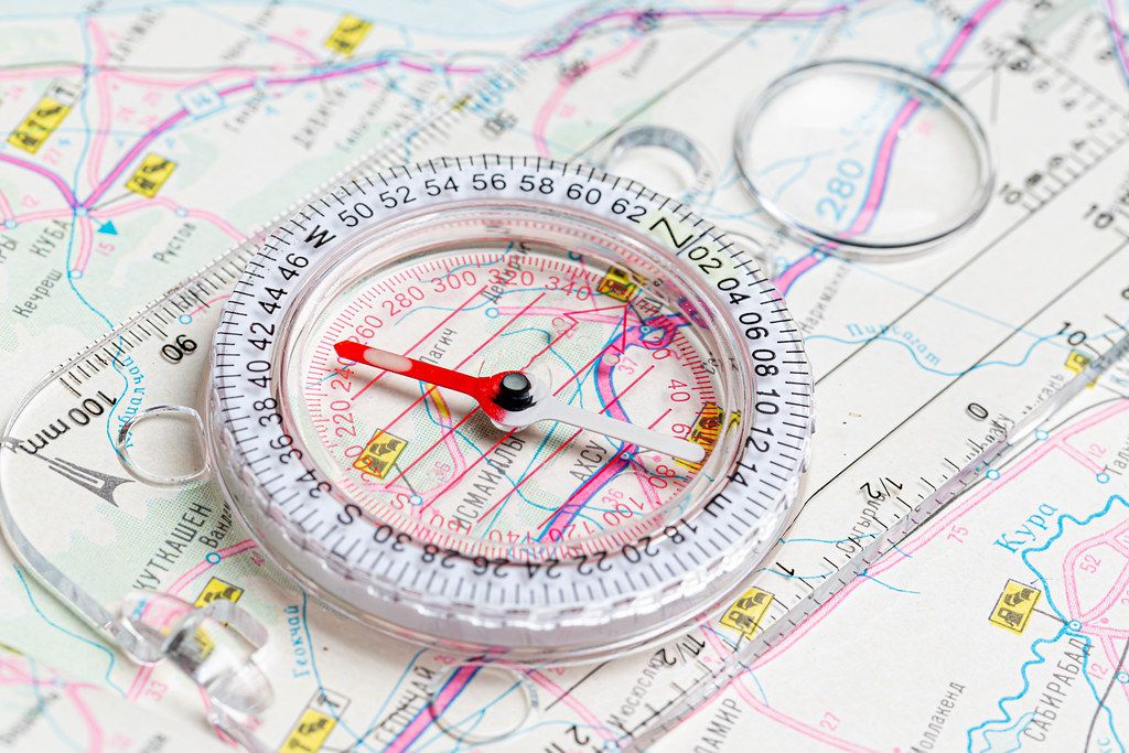 The compass lies on the map. Terrain orientation concept Creative