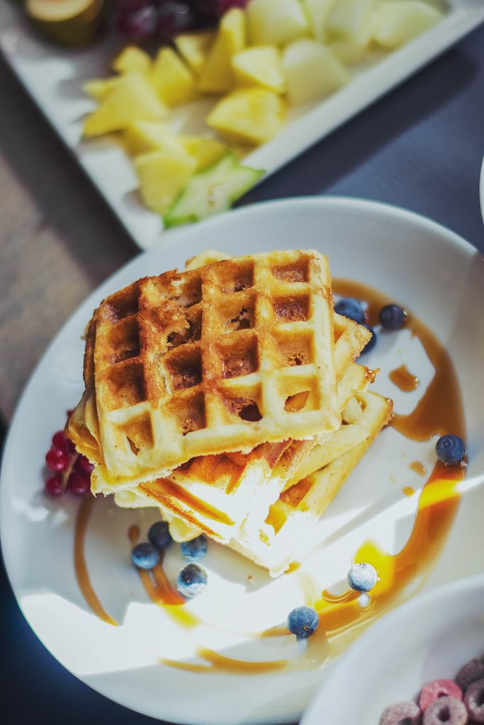 Belgian waffles poured with honey and blueberries. Top view Creative