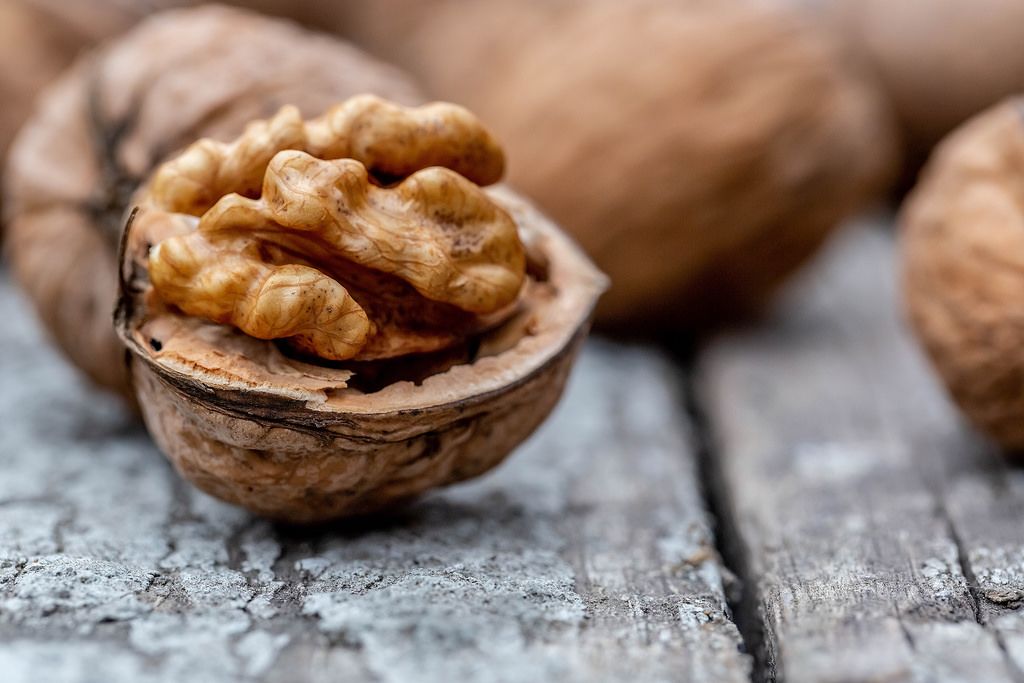 Whole and half walnuts on wooden background Creative Commons Bilder