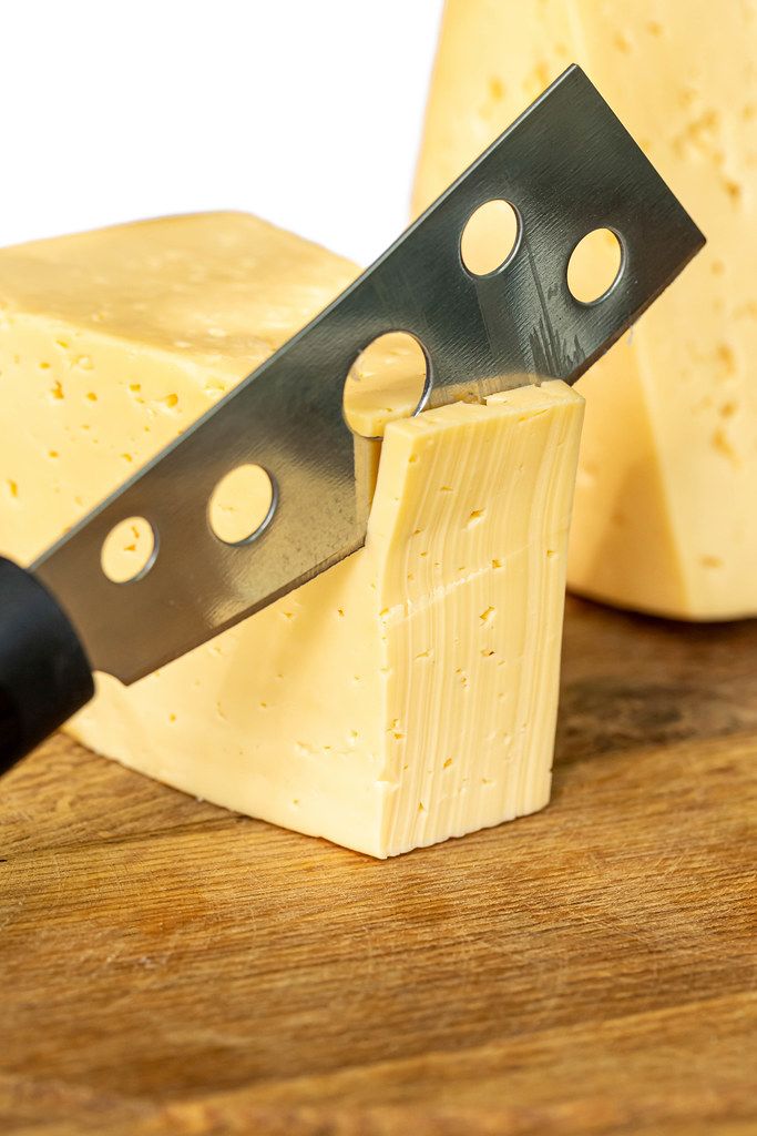 Cutting cheese with a knife, closeup Creative Commons Bilder