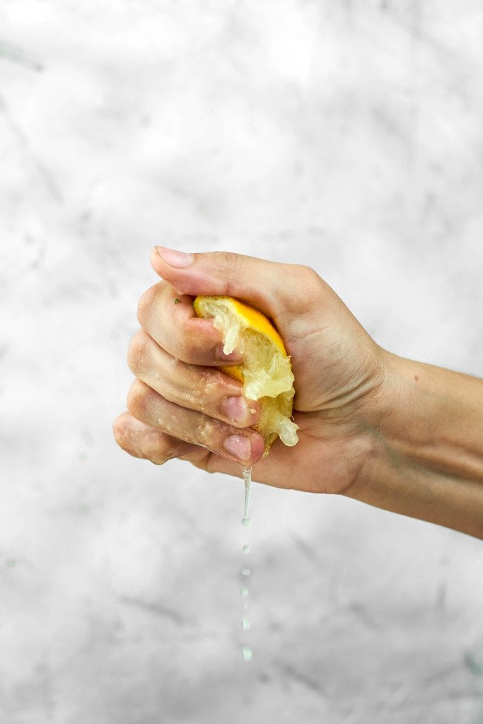 Partial view of woman hand squeezing fresh lemon Creative Commons Bilder