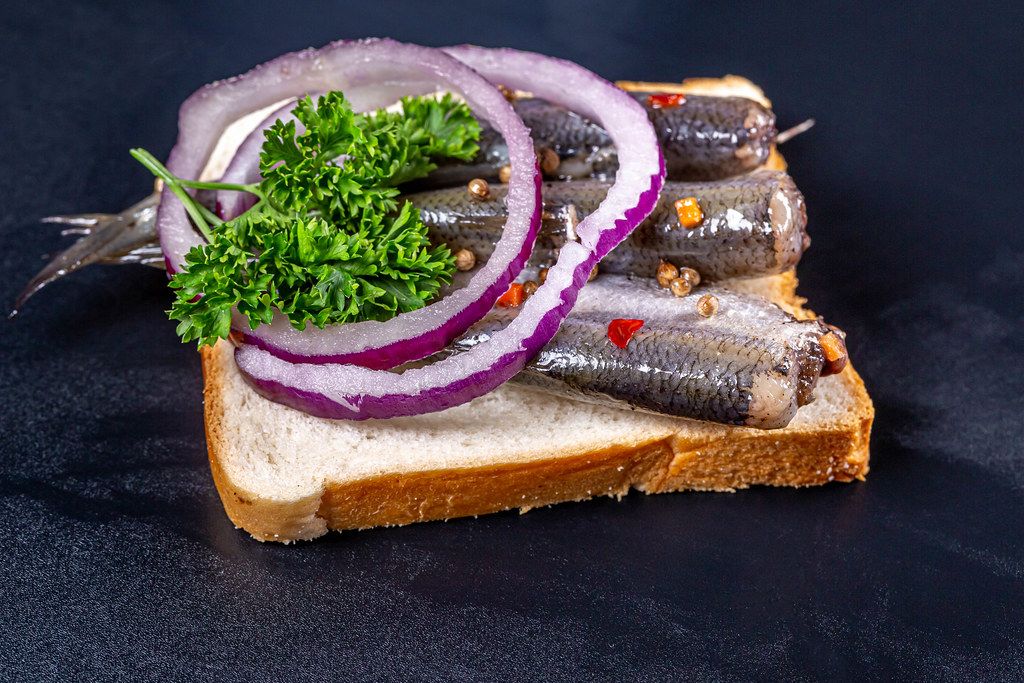 Marinated small fish with spices, purple onion, lemon and parsley
