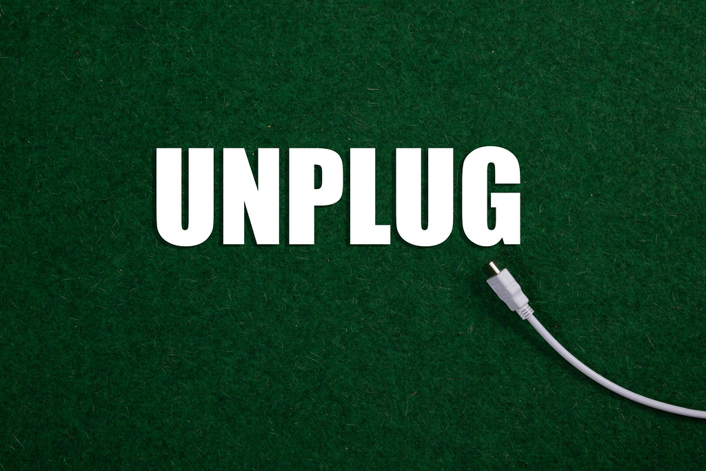 USB cable and Unplug text on green grass Creative Commons Bilder