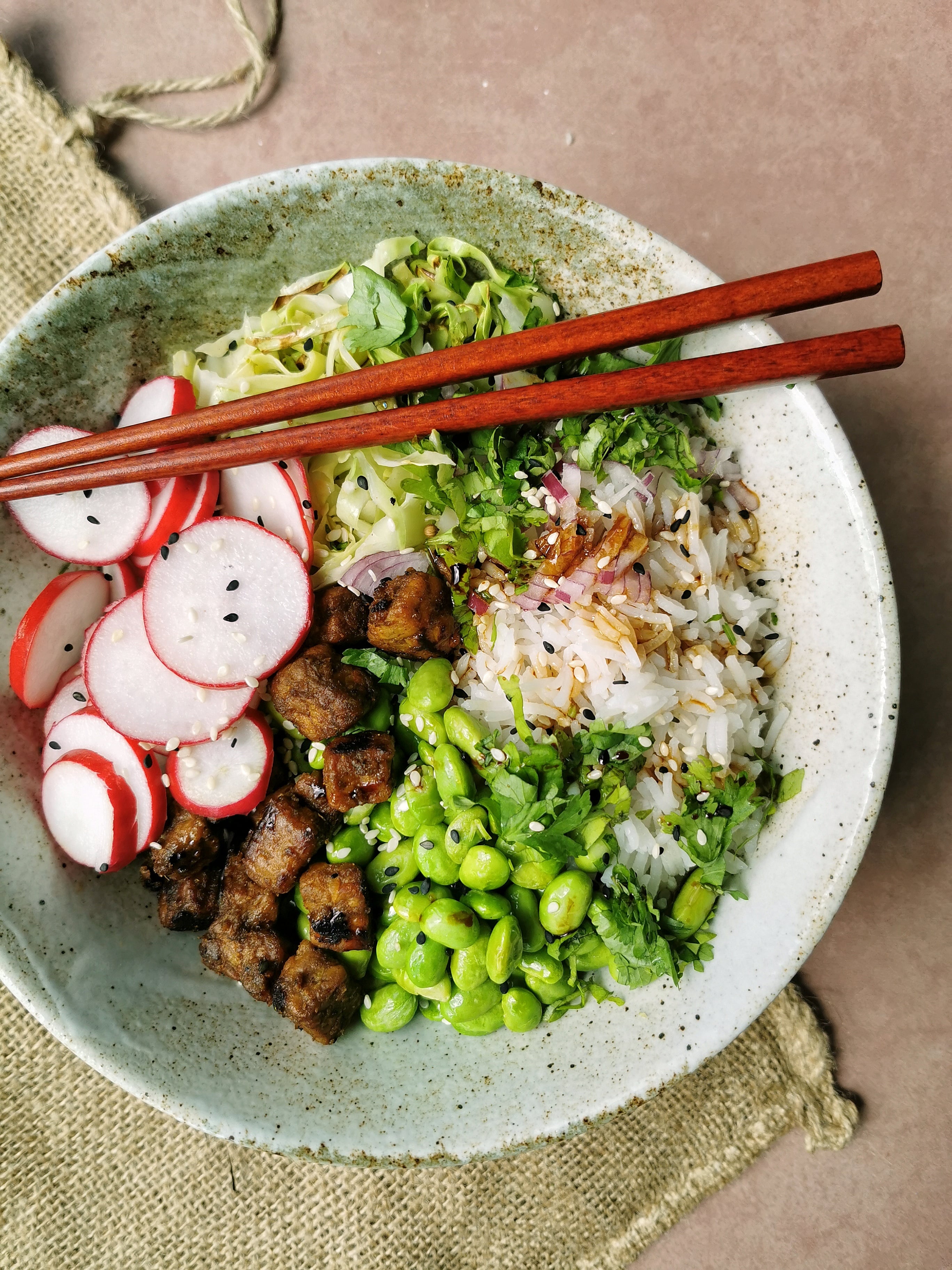 Vegan poké bowl met tempeh, spitskool, radijs en edamame bonen