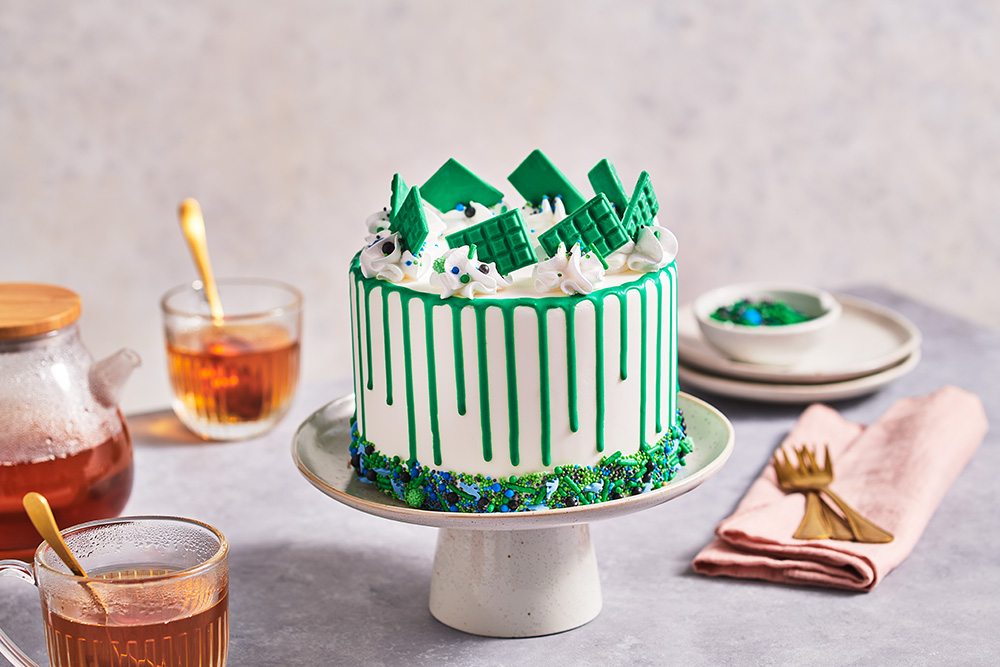 Green drip cake with sprinkles and mini choco bars FunCakes