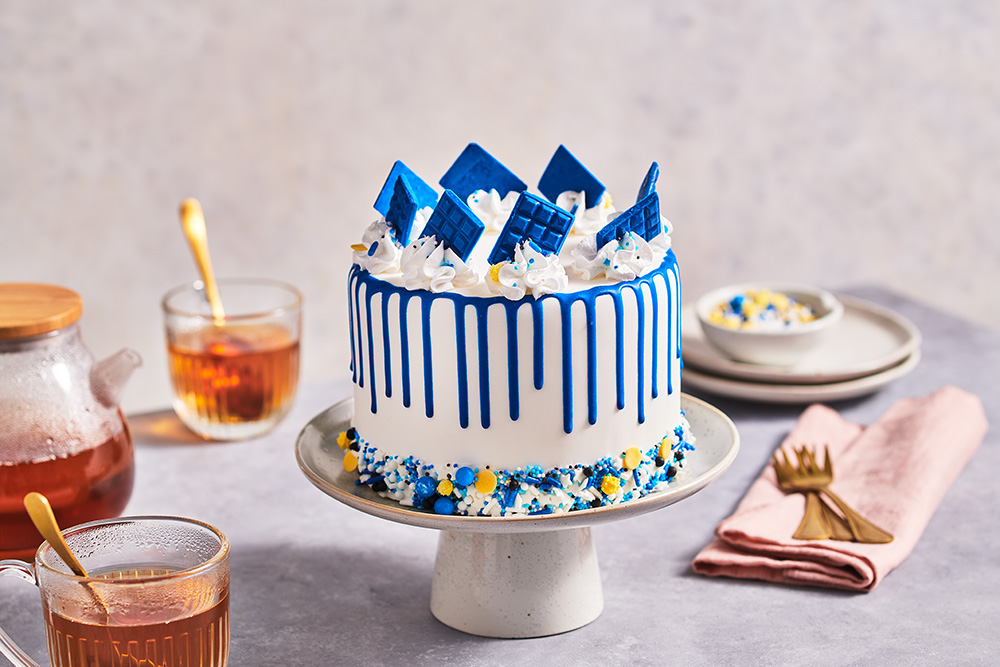 Royal blue drip cake with sprinkles and mini choco bars FunCakes