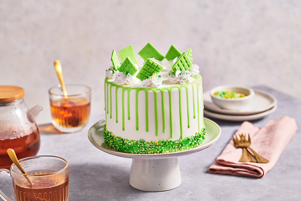 Spring green drip cake with sprinkles and mini choco bars FunCakes