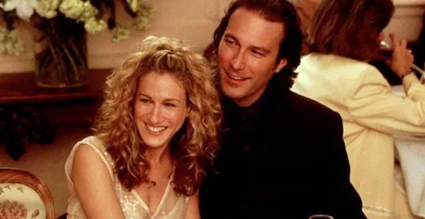 Carrie and Aidan smiling and talking at a restaurant