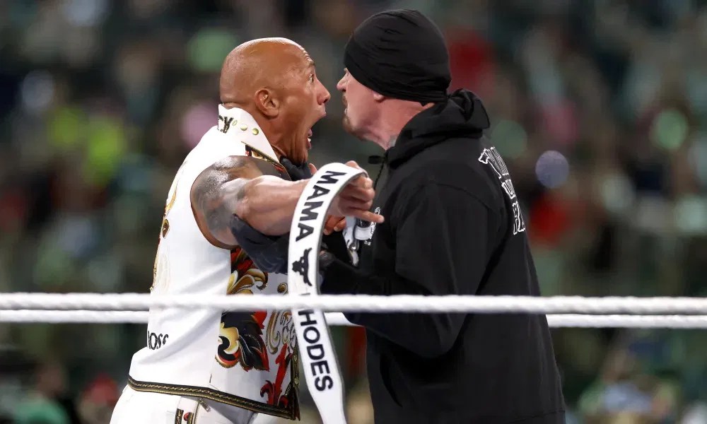 The Undertaker grabs The Riock;s Throatbfor a chokeslam