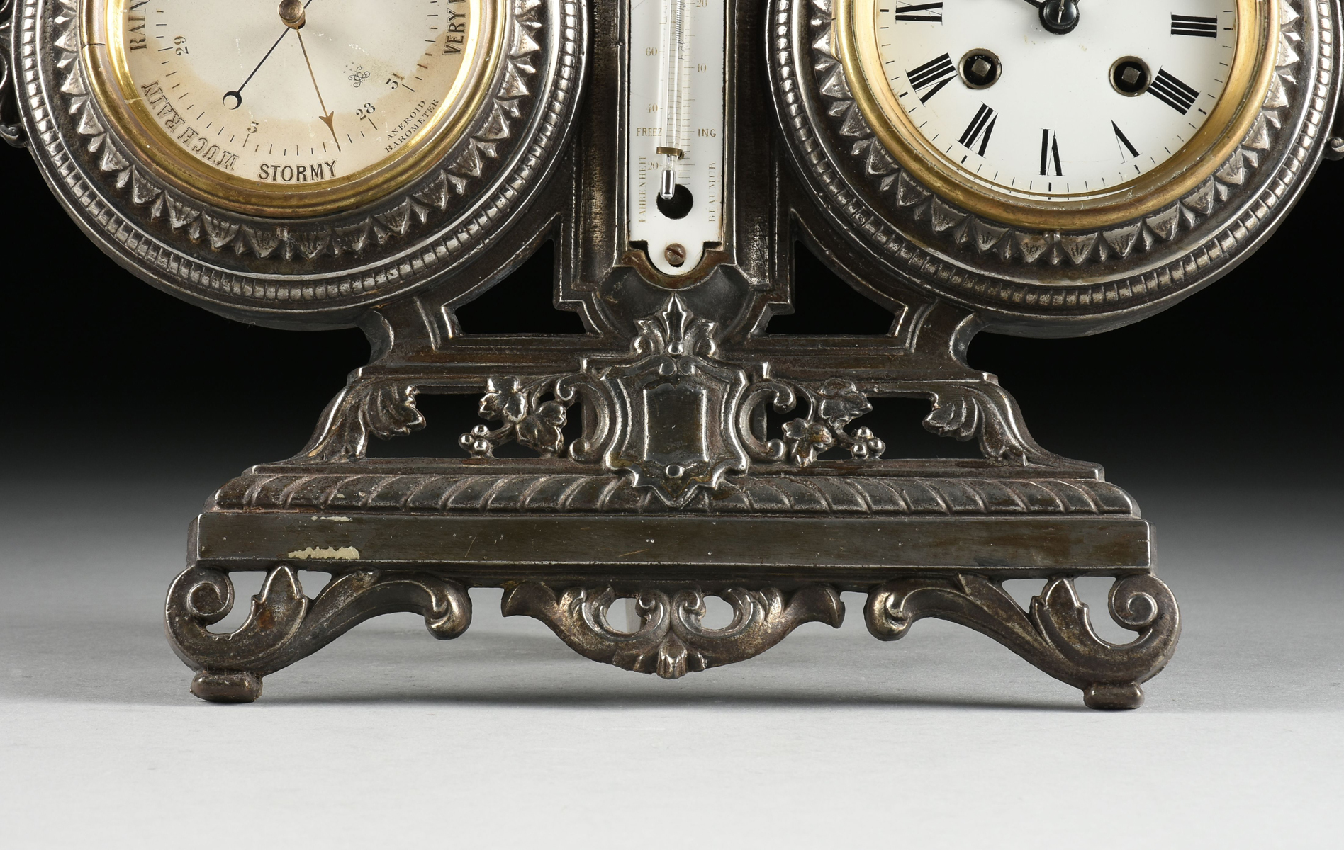 A VICTORIAN POLISHED CAST IRON DESKTOP BAROMETER, THERMOMETER, AND