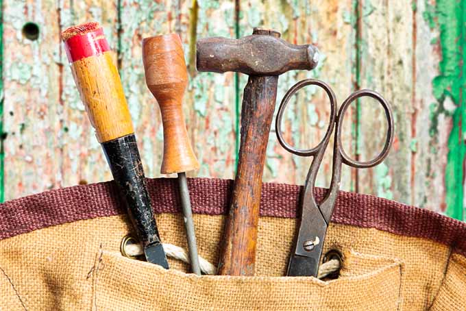 A close up horizontal image of tools in a tote bag.