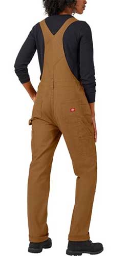 A close up vertical image of a woman wearing brown overalls over a black shirt, pictured from the back.