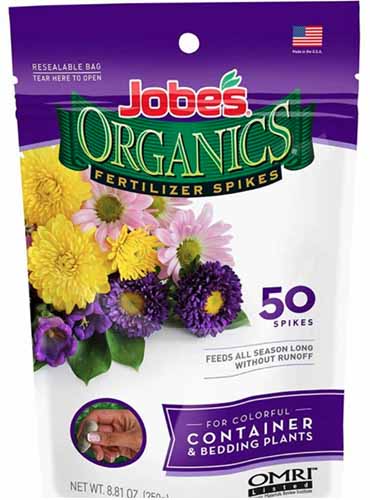 A close up vertical image of Jobe Organics Fertilizer Spikes isolated on a white background.