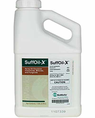 A close up vertical image of a plastic bottle of SuffOil-X isolated on a white background.