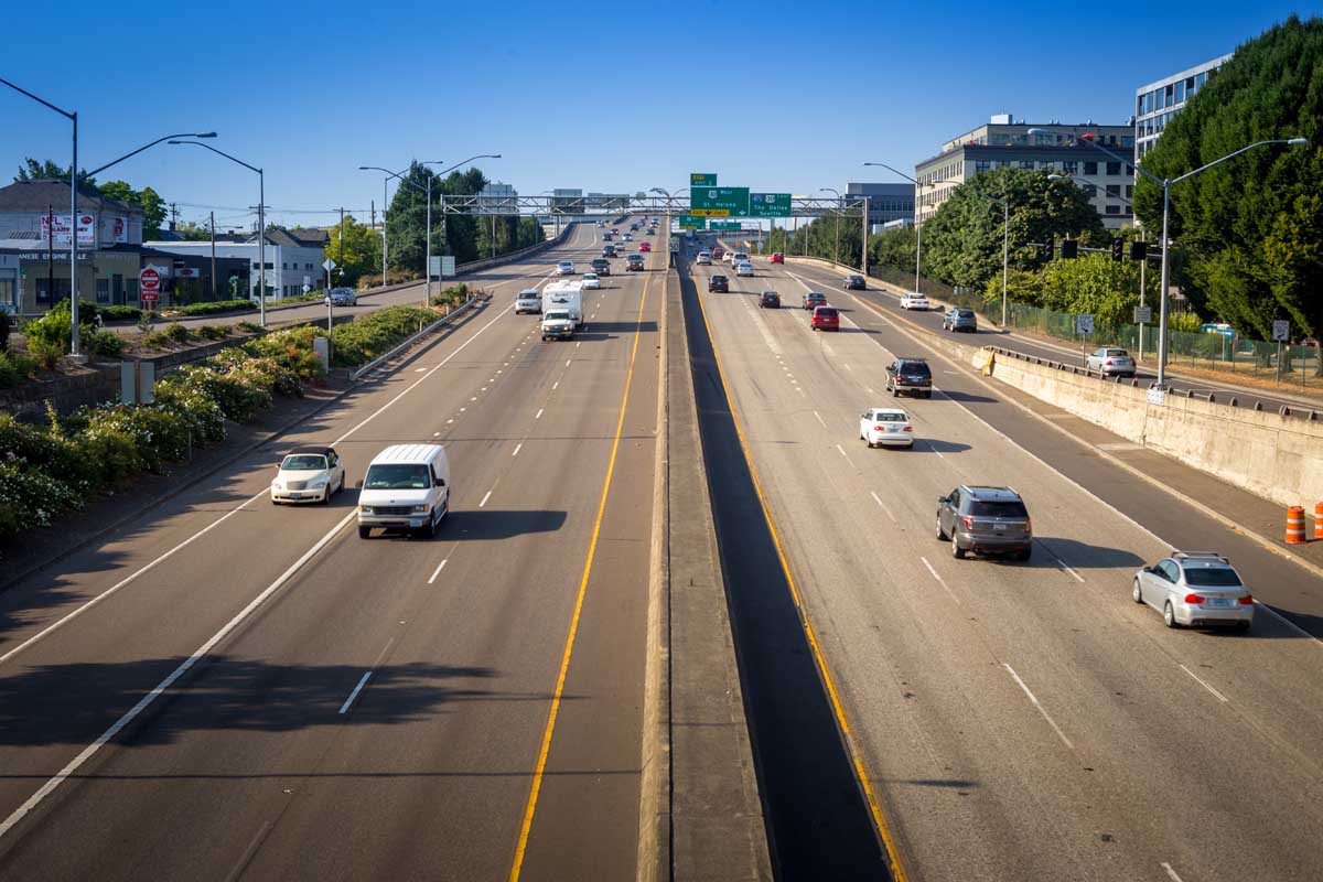 A horizontal image of a highway in Orgeon with rose bushes planted on the side of the road.