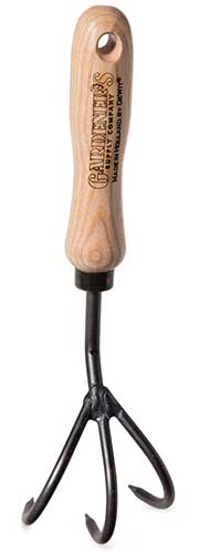 A close up vertical image of a hand held cultivator isolated on a white background.