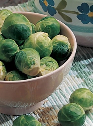 A close up of a bowl of ‘Catskill’ brussel sprouts, with some spilling over the side.