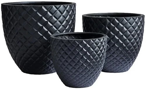 A close up of three dark gray stone planters isolated on a white background.