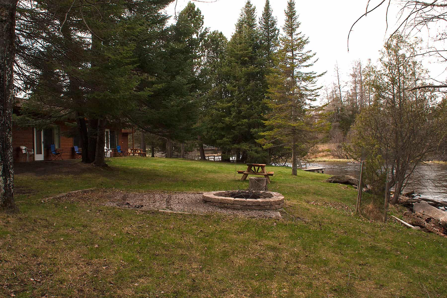 Firepit by the river. Gates Au Sable Lodge